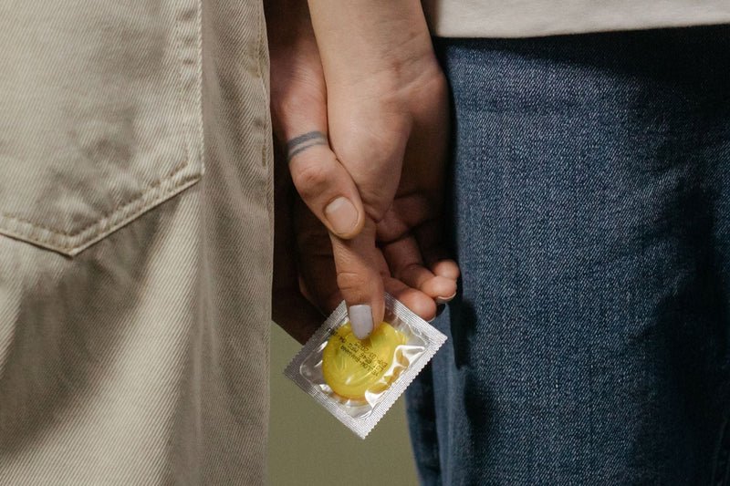 Due persone con una confezione di preservativo tra le mani